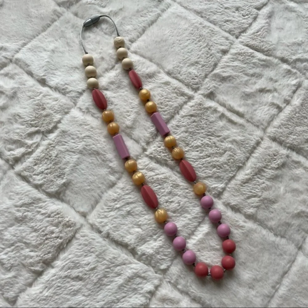 Itzy Ritzy | Teething Happens Chewable Mom Necklace | Pink & Gold